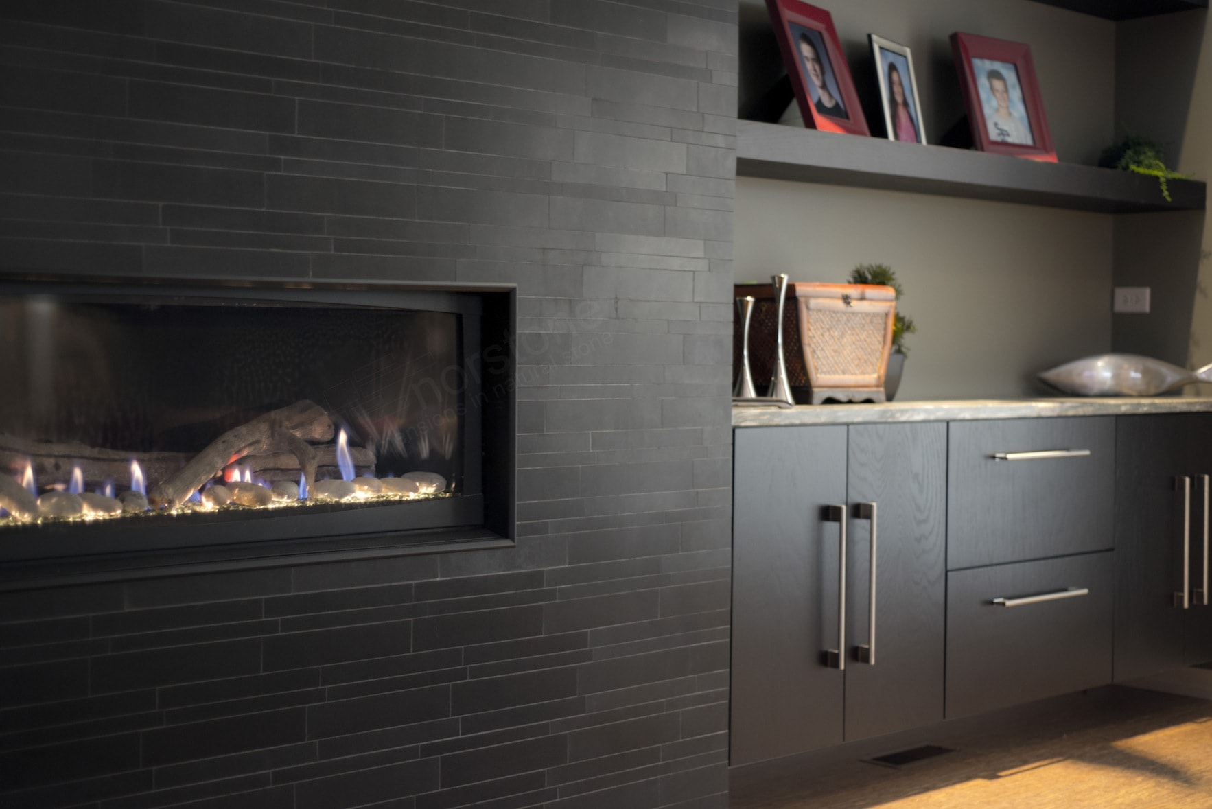 Modern All Glass Fireplace Insert set at waist level on a black stone tile fireplace